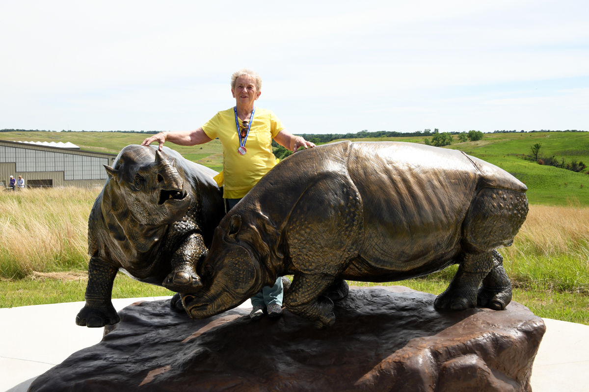 050 Agnes Loukota poses with the bronze rhinos at Ashfall.JPG